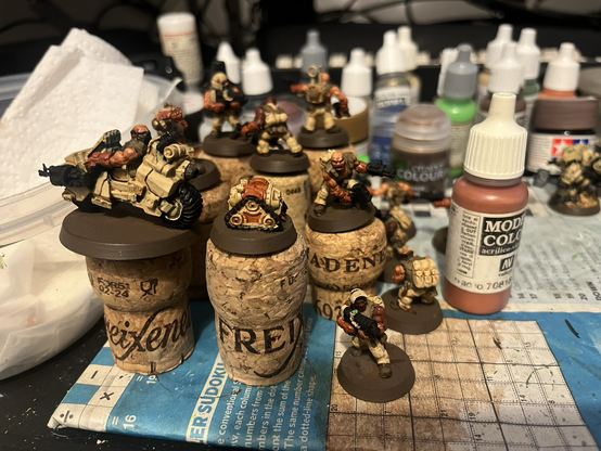 Some partially painted desert dwarf minis on a painting table.
