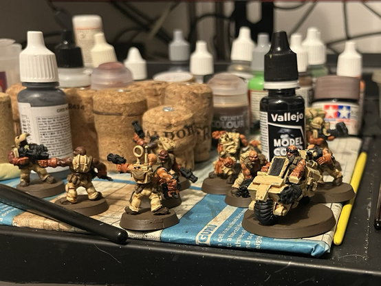 Some partially painted desert dwarf minis on a painting table. They are nearly finished now.