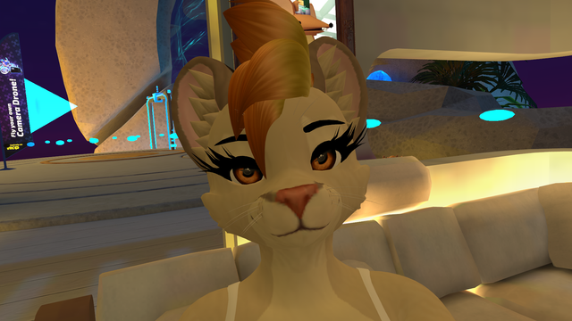 A image of my fursona Flame in VRChat. She is a mountain lion with orange eyes and fire-colored hair. She is looking right at the camera while smiling slightly.