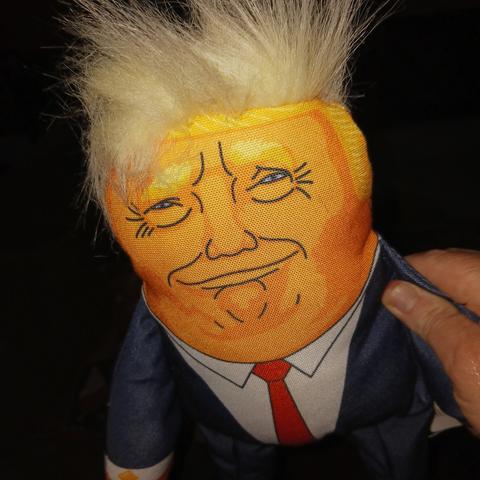 An orange-faced dog toy in the image of Donald Trump.