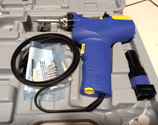 Hakko FR302, brand new, sitting in it's box. Inside the loop of cable rests resistors in a bag that I will need to convert to US voltage