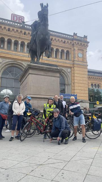 Eine Gruppe Fahrradfahrer: innen vor dem Ernst-August-Denkmal Hannover Hbf.