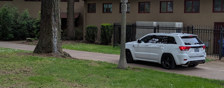 somebody in a brand new SUV driving down the sidewalk