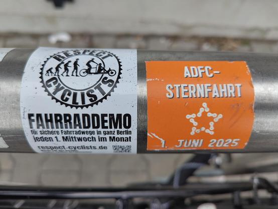 Zwei Aufkleber an einem Fahrradbügel
1. Aufkleber
Respect Cyclist Logo
Fahrraddemo für sichere Radwege in ganz Berlin 
jeden 1. Mittwoch im Monat

2. Aufkleber
ADFC-Sternfahrt Juni 2025
inkl. Sternfahrt-Logo