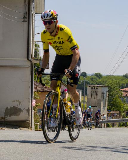 a professional cyclist in a yellow jersey riding a yellow bike