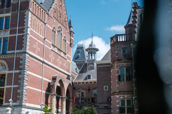 The intricate architecture of the Rijksmuseum in Amsterdam under a clear blue sky.