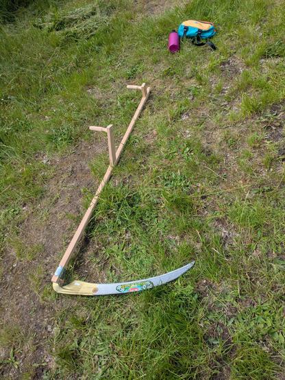 Eine Sense liegt im Gras