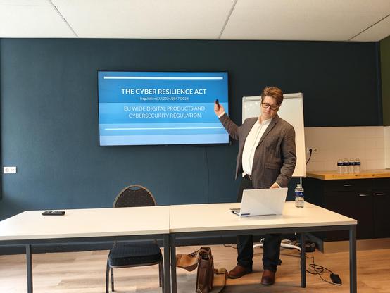 Michael August Bournique presenting a slide titled the cyber resilience act.