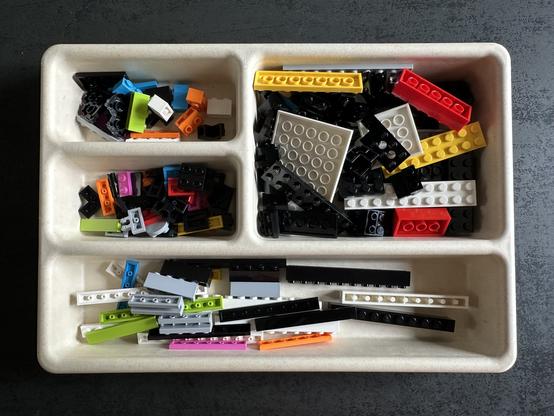 Une boîte de tri avec des pièces Lego de multiples formes et couleurs