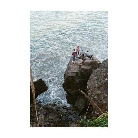 Moroccan fishermen fishing from the top of a rock in Rabat.