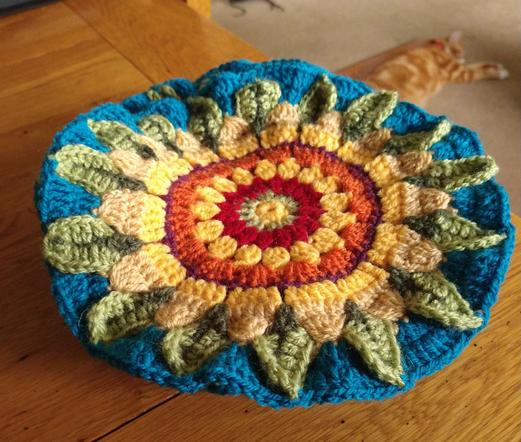 Sunflower design crochet flowers, part of a Jane Crowfoot Fields of Gold design 
They have green and red centres with yellow and green petals, and a blue edge