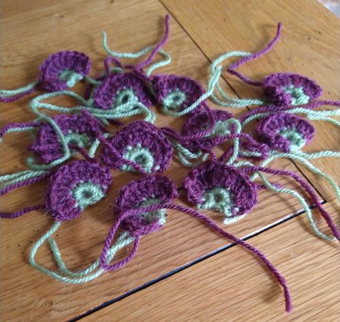 Green and cranberry colour half circles for the edging of a Jane Crowfoot Fields of Gold design.