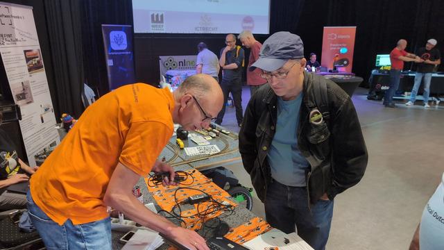 De NLLGG stand op T-DOSE, met 1 van onze leden die iets laat zien aan een bezoeker.
