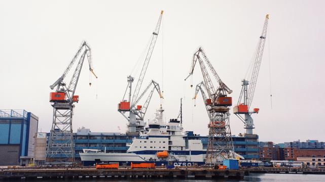 Photo in a harbour with cranes and a boatie