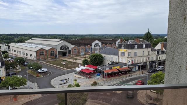 Vue de la façade en brique et grands portails des anciennes usines de la Société Française à Vierzon (ça fabriquait des tracteurs, il y en a un exposé sur l’Esplanade).
Derrière la façade, toute une partie de la couverture manque, exposant la charpente métallique. 
Derrière,  les forêts entre Berry et Sologne.