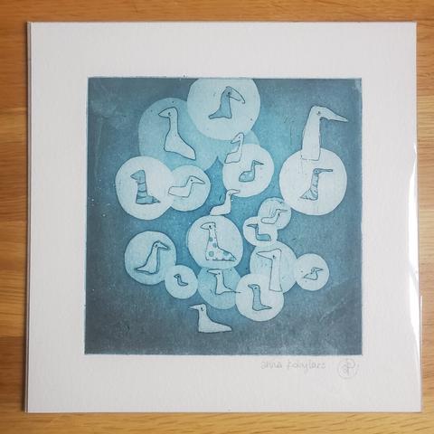 Photo d'une gravure emballée représentant des petits oiseaux-chaussettes toustes différent.s et cerclés de disques de différentes couleurs s'interpénétrant ou non en fonction de la densité de la couleur.