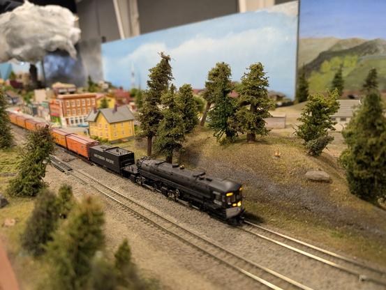 An N-scale Southern Pacific Cab-Forward comes steaming down one of the modules
