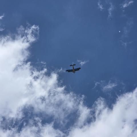 Ein Flugzeug am Himmel, von unten. Es sind auch ein paar Wolken dabei