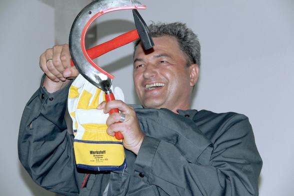 Armin Medosch at his 50th Birthday Party, laughing and holding a hammer and a sickle, Vienna, September 16, 2012.