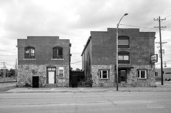 A pair of multi-story buildings, each clad in stone in the first level and brick on the upper level(s). The right building houses "King City Games".
