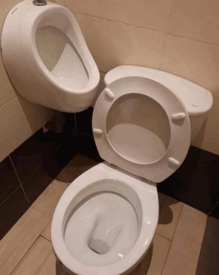 A toilet and a urinal in a men's restroom that are right next to each other in a corner.