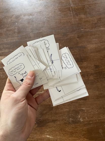 the author's hand holds a grip of home made #TheCrimeCats stickers