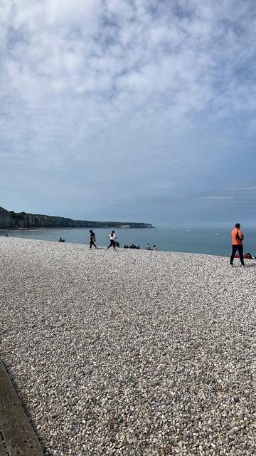 Plage de galets de Fecamp, ciel bleu et falaise au loin