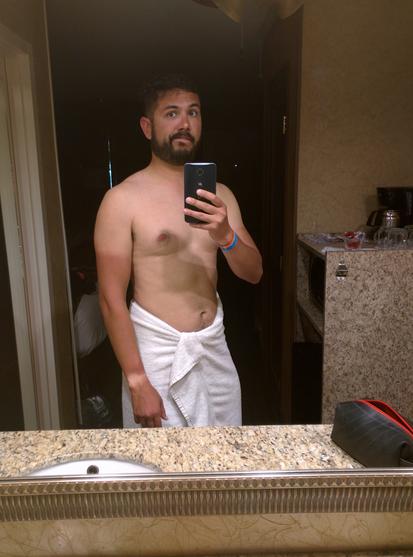 Jorge, 10 years ago, in front of a mirror wearing only a towel. He has a very noticeable cyclist tan.