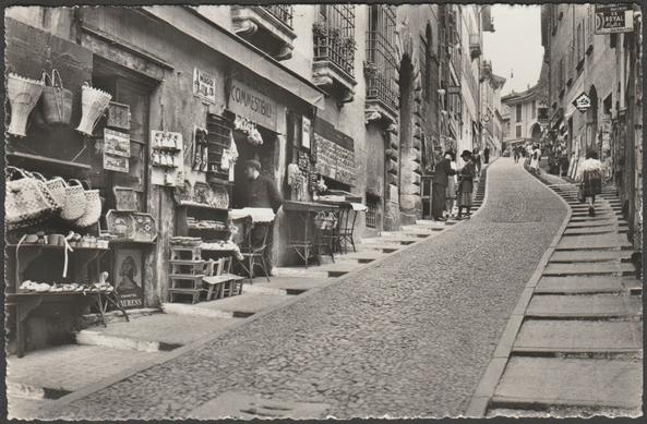 Monochrome real photographic postcard showing a view of the Via Cattedrale in Lugano in the Canton of Ticino, Switzerland.

Published by Giuseppe Mayr, Lugano, No 2722, c.1940s.

Postally unused.

Excellent condition, with minimal corner bumps.