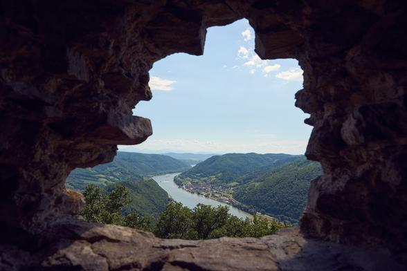 Photo through a small stone built window down into the danube valley