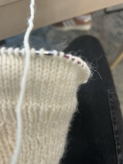 The first part of a white wool top on knitting needles