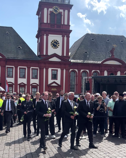 Bundesinnenminister Dobrindt mit weißer Rose in Menschenmenge