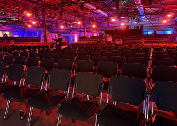 Saal mit Stuhlreihen in rotem Licht