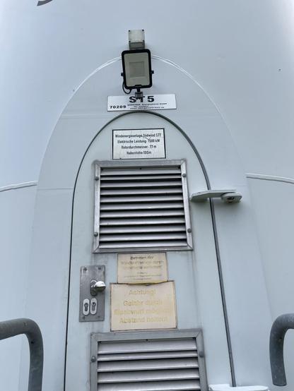 The door at the basement of a large wind turbine shaft. A plate telling that this turbine produces up to 1500 kW of power