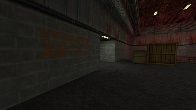 In this picture you can see the hall with the ramp again. This time from the other side. You can see the passage to the hallway which leads to the small room with the radio. From left to right you can see a wall where Storage Area 2 is written in orange lettering, the passage to the hallway, where a yellow illuminated lamp is attached to the top, a small and large wooden box, and a red railing that runs behind the box. In addition, you can see that the ceiling is made of red stone. And on the left under the stone ceiling you can see a steel beam and two yellow-lit lamps attached to the rock ceiling. This is on the map de_nuke in the game Counter-Strike 1.6.