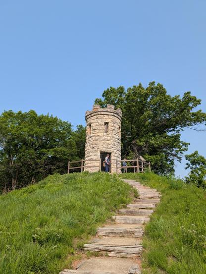 Image of the Julian Dubuque Monument and trail leading up to it from the river, in Dubuque, Iowa.  The monument is a stone tower that looks very much like a free-standing castle turret.