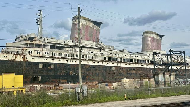 A picture of the SS United States docked in Mobile, Alabama. It looks greatly worn and weathered.