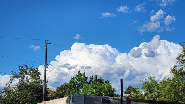 color photo of fluffy white clouds and blue sky