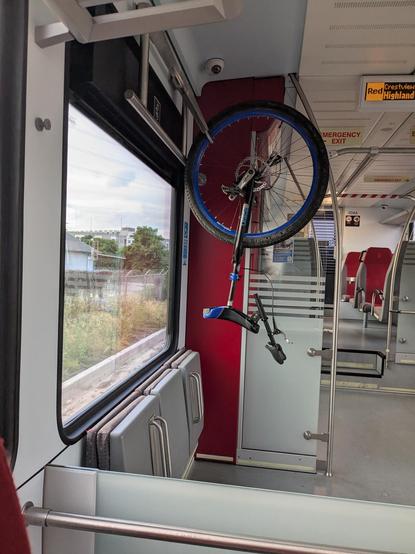 a unicycle hanging from a bike hook on a train