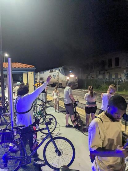 some cyclists greeting an arriving amtrak train