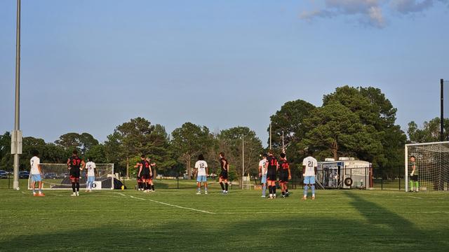 Teams line up on the pitch ahead of a free kick.