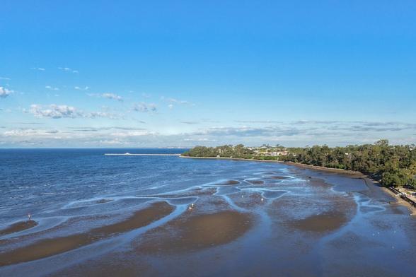 An aerial shot, taken from over the beach at lowtide from the Sandgate foreshore, looking towards and along the Shorncliffe promenade, towards Shorncliffe jetty