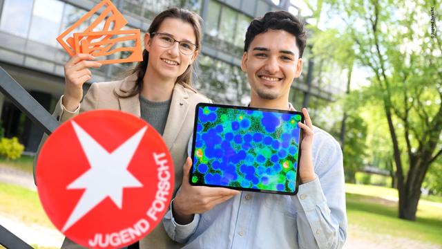 Zu sehen sind Svenja Bergling (19) aus Rödermark und Cumhur Utku Dagli (20) aus Hamburg. Sie halten das Logo von Jugend forscht und ein Tablet hoch.