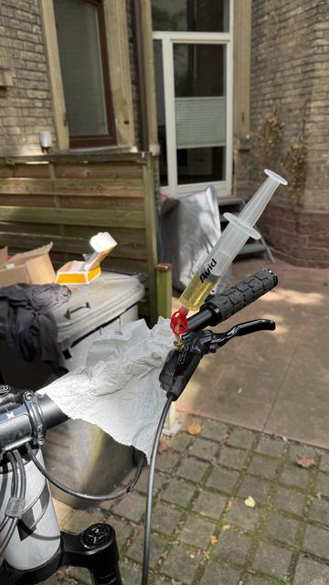 Mountainbike Super-Enduro Tyee 6 von der Marke Propain am Reparatur-Ständer. Bremshebel vorne- Entlüftung via Spritze.