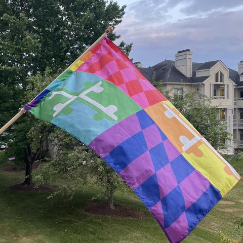 Maryland-flag themed Pride flag extended in a light breeze on a nice day.