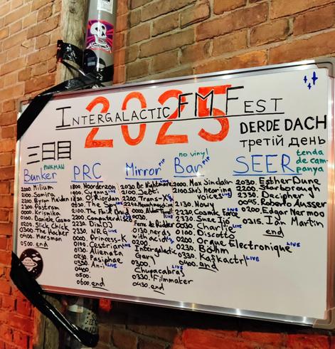 Saturday timetable scribbled on a whiteboard hanging on a brick wall