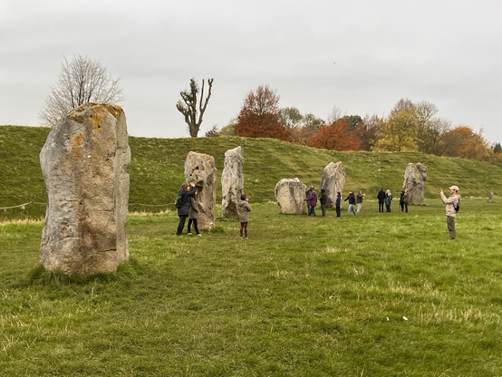 Walkers enjoying a run of standing stones at Avebury.