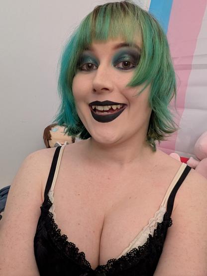 Revy wearing green ish blue ish black eyeshadow & black lipstick with a black lace dress
