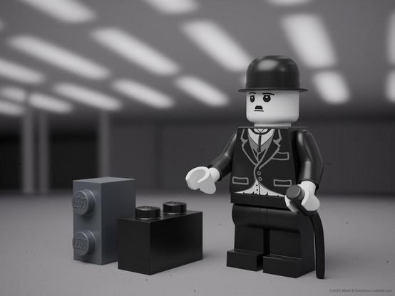 Charlie Chaplin minifig model with two small bricks as baggage.