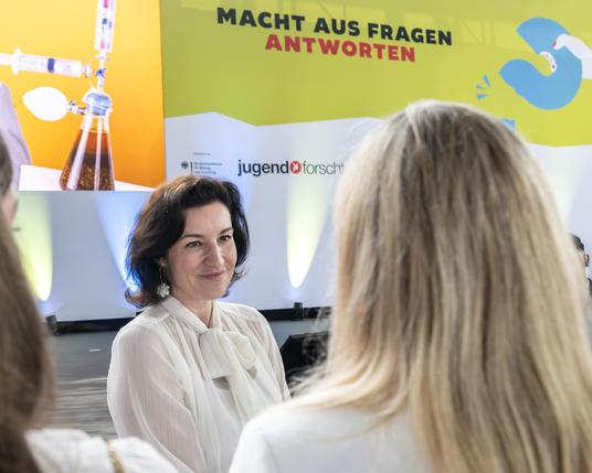 Bundesforschungsministerin Dorothee Bär unterhält sich mit einer Jungforscherin kurz vor dem Bundesfinale des Wettbewerbs Jugend forscht.